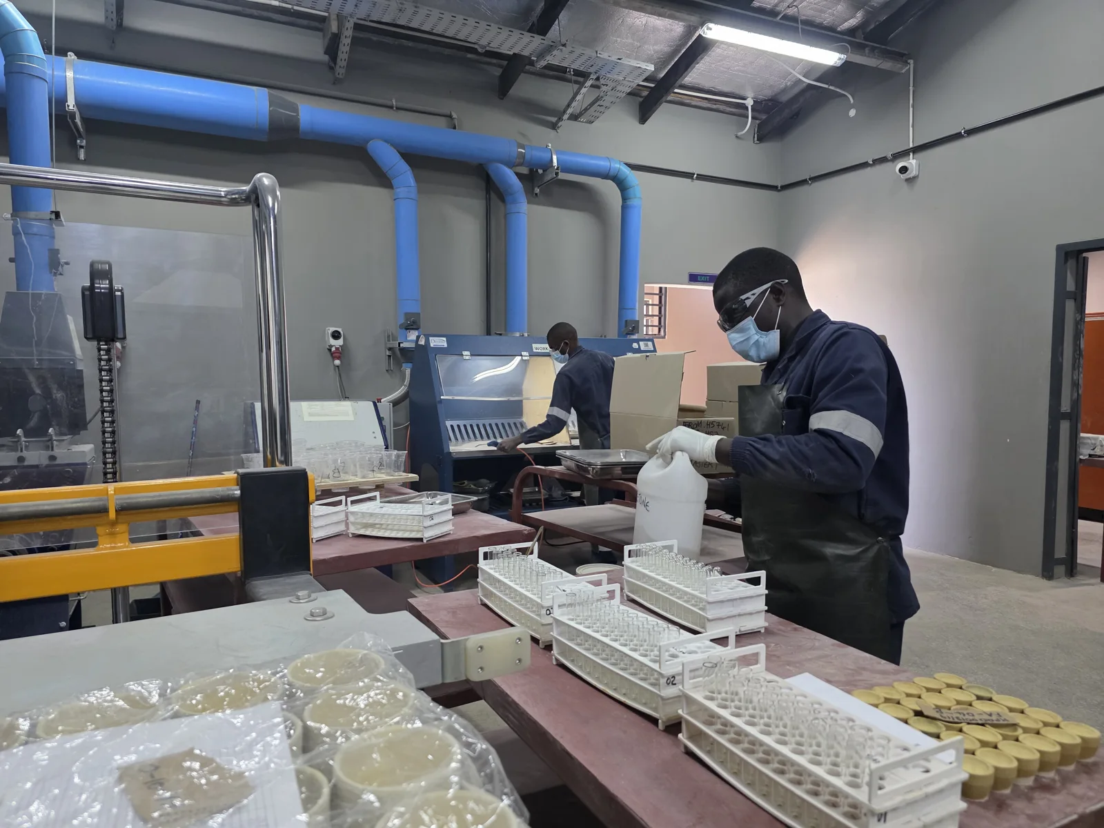 Laboratory technicians working through the fire-assay workflow